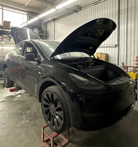 Майстер Autokompleks проводить огляд ходової частини Тесла на підйомнику